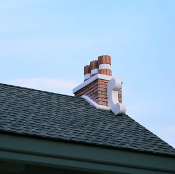 Dark shingle roof and brick chimney