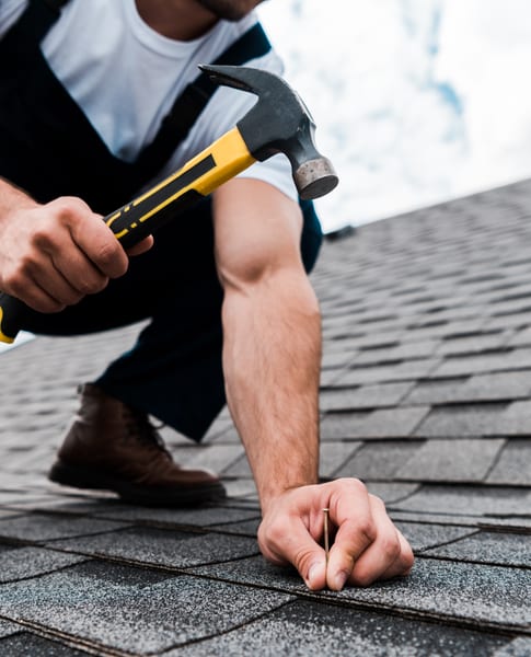 Hammering a shingle patch into place