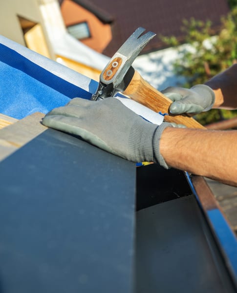 Nailing new shingles at the roof edge