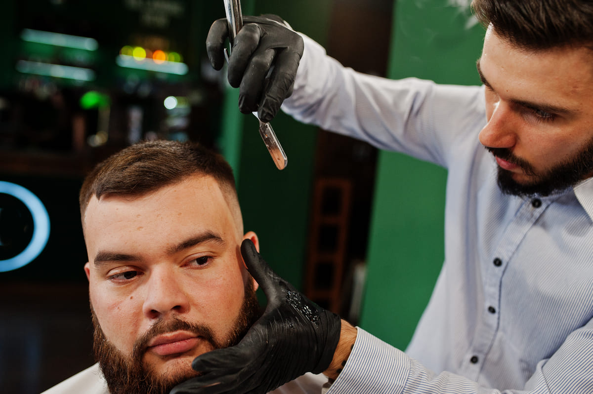 Andre working a straight razor in black gloves