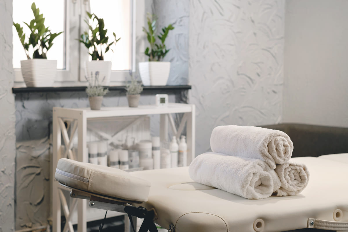 The treatment room, bright, with fresh rolled towels on the bed