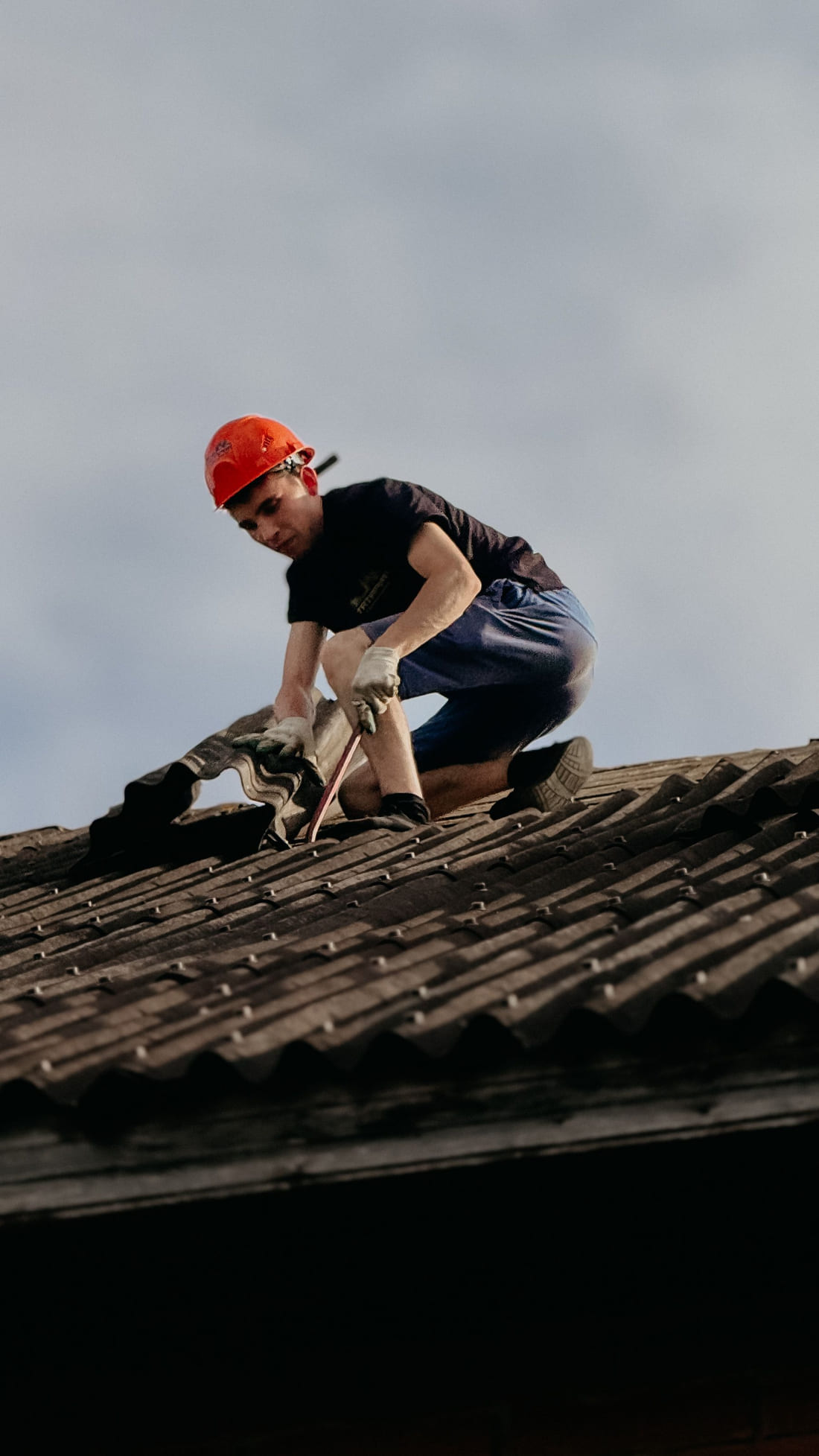 A Ridgeway roofer replacing tiles on a steep roof