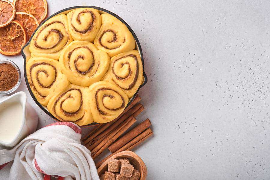 Fresh glazed cinnamon rolls with cinnamon sticks